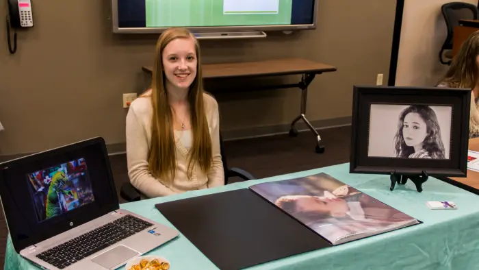 Image of student showcasing their photos at table.