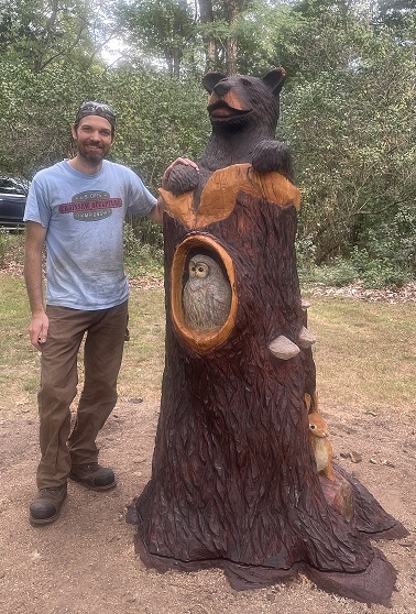 Picture of a carved bear and owl in a tree