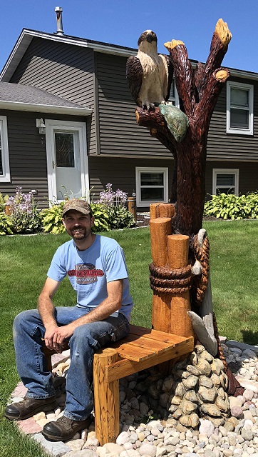 Picture of a carved osprey in a tree with a fish