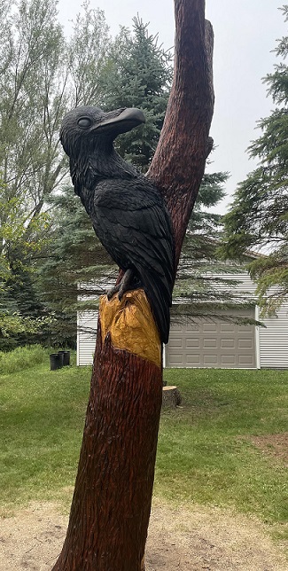 Picture of a carved raven in a tree
