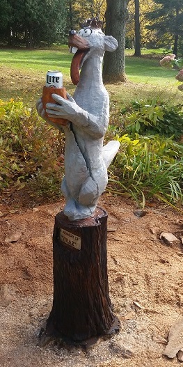 Picture of a carved memorial of a cartoon weasel with a beer can holder