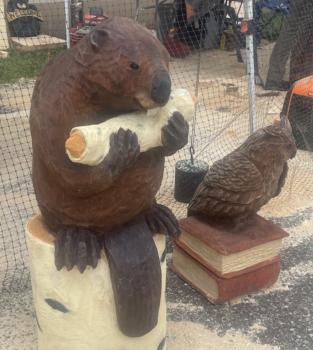 Picture of a carved beaver sitting on a log, eating a log