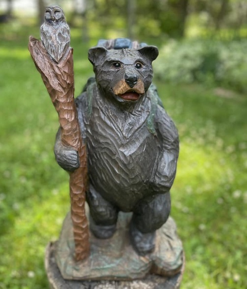 Picture of a carved bear with a hiking stick