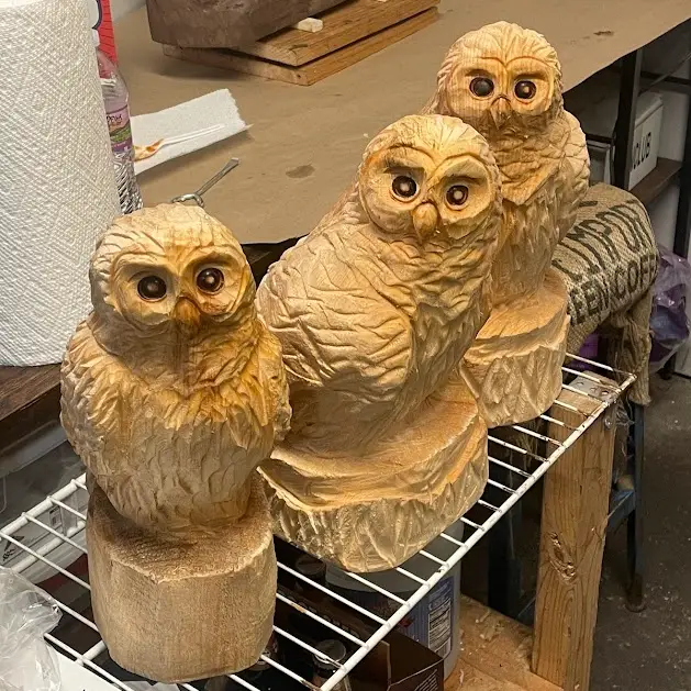 Carved wooden owls, stained a dark color.